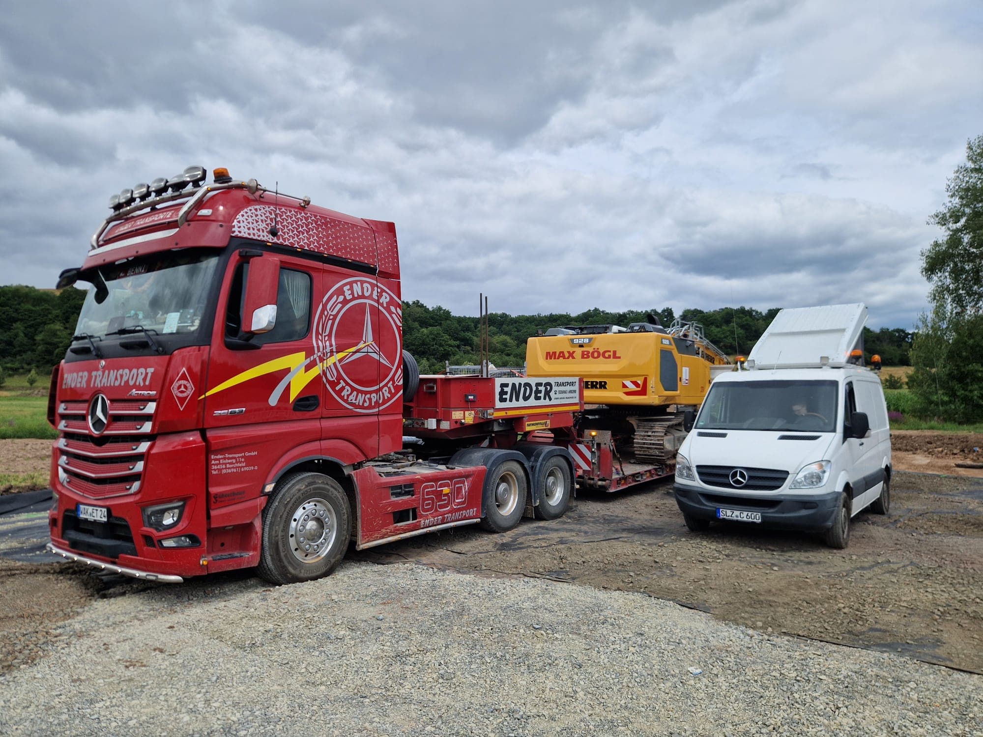 Roter Ender-Tieflader mit Bagger und Begleitfahrzeug