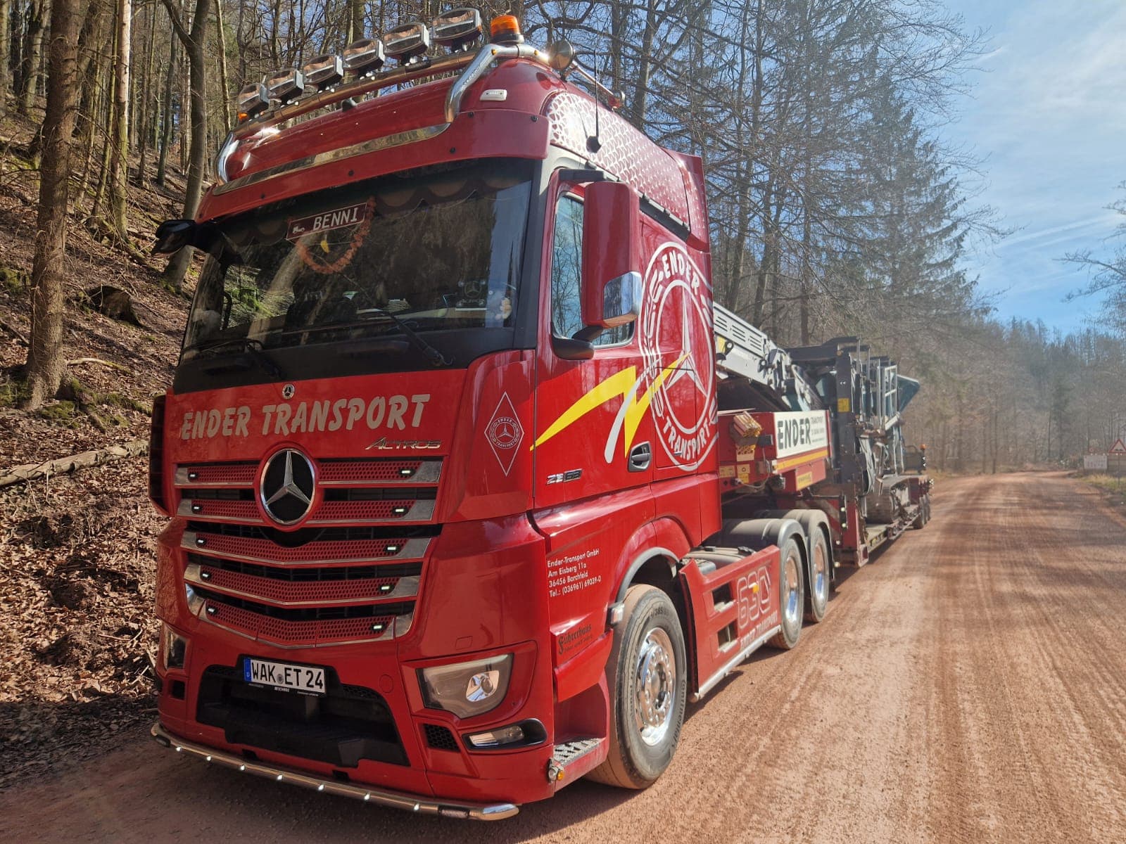 Ender-Tieflader mit Baumaschine auf einem Waldweg